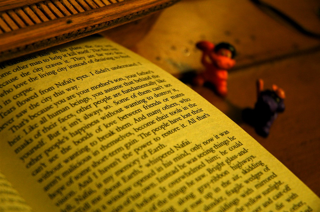 an open book showing text with two small toys next to it