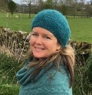 Clare Viner in a knitted hat walking in the countryside.