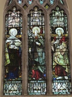 Stained glass window with three saints.